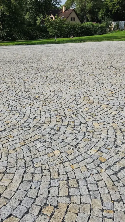 Příjezdová cesta vydlážděná žulovou kostkou 8/11 v šedožlutém melanži, kladená do segmentových oblouků